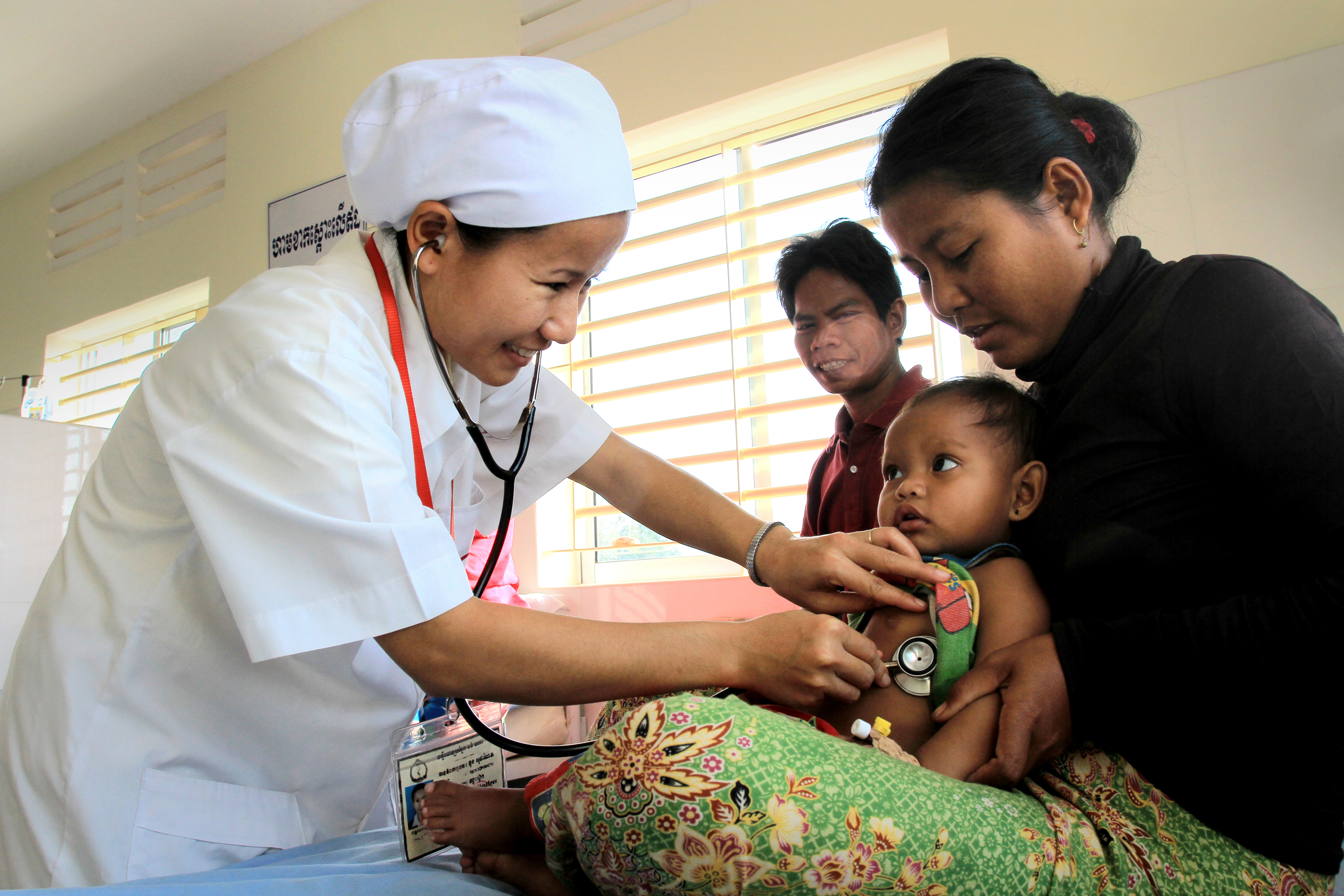 Healthcare worker examines baby