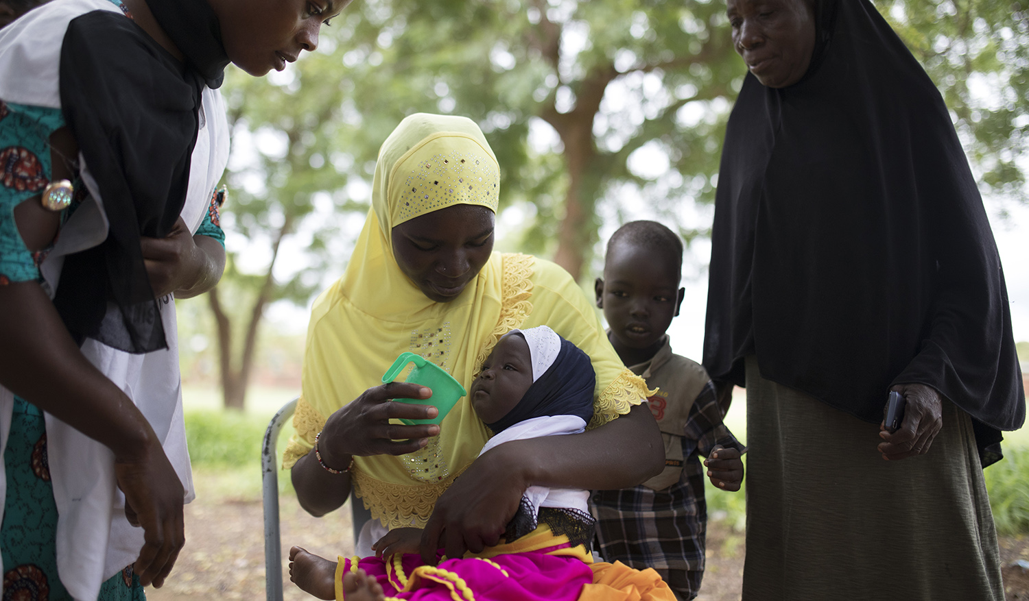 Mother receives anti-malaria drugs for her children in Zitenga, Burkina Faso on August 26, 2018. Photo: Dominic Chavez