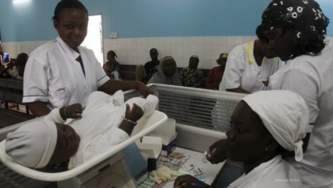 Healthcare workers weight baby / photo credit: Reuters